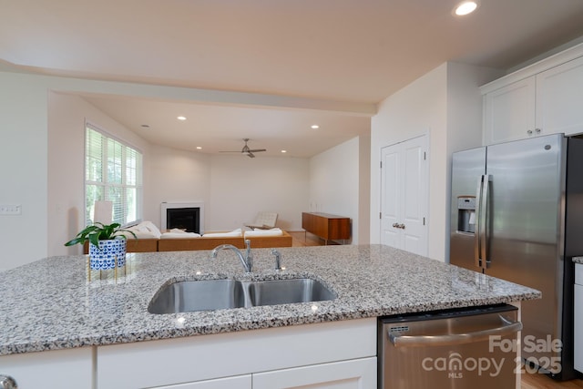 2407 Baxter Pl SE, Concord, NC 28025 - kitchen featuring stainless steel appliances, white cabinets, light stone counters, open floor plan, and recessed lighting