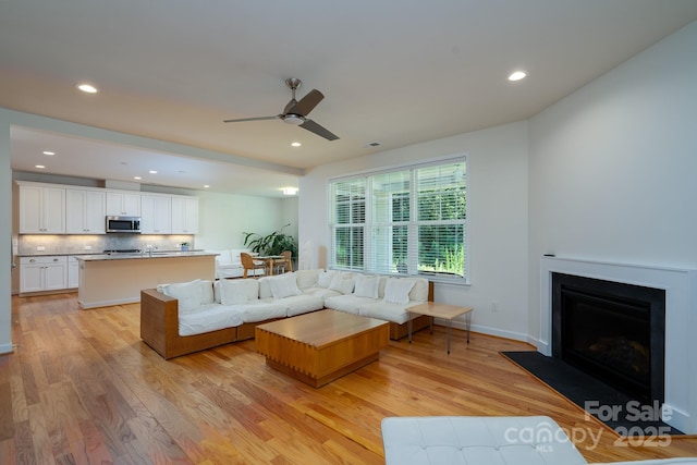 2407 Baxter Pl SE, Concord, NC 28025 - living room with light wood-type flooring, a ceiling fan, recessed lighting, and a fireplace
