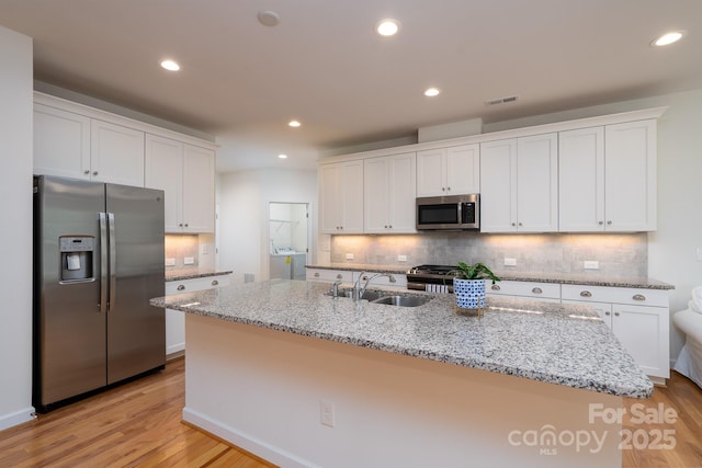2407 Baxter Pl SE, Concord, NC 28025 - kitchen featuring appliances with stainless steel finishes, white cabinets, backsplash, recessed lighting, and light wood-style flooring