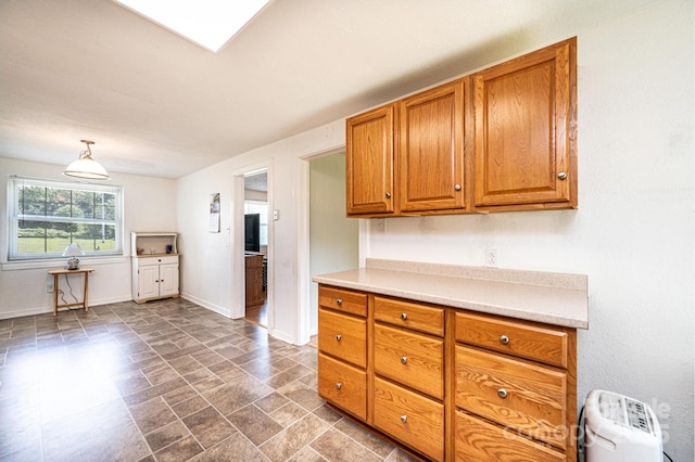 559 15th Ave SE, Hickory, NC 28602 - kitchen with brown cabinets, light countertops, dark stone finish floors, and pendant lighting