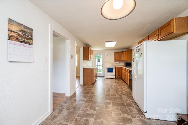 559 15th Ave SE, Hickory, NC 28602 - kitchen featuring white appliances, brown cabinetry, light countertops, and stone finish flooring