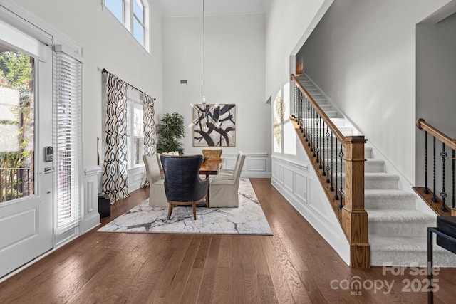 16522 Flintrock Falls Ln, Charlotte, NC 28278 - entryway with stairway, wood-type flooring, crown molding, a towering ceiling, and a wainscoted wall