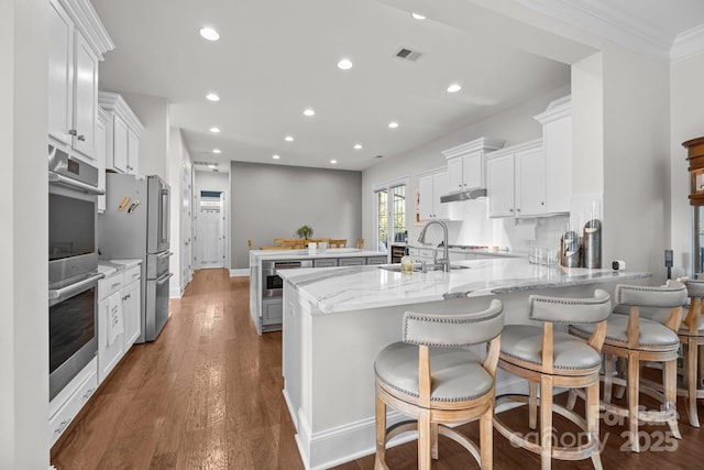 16522 Flintrock Falls Ln, Charlotte, NC 28278 - kitchen with a peninsula, appliances with stainless steel finishes, recessed lighting, dark wood-style floors, and white cabinetry