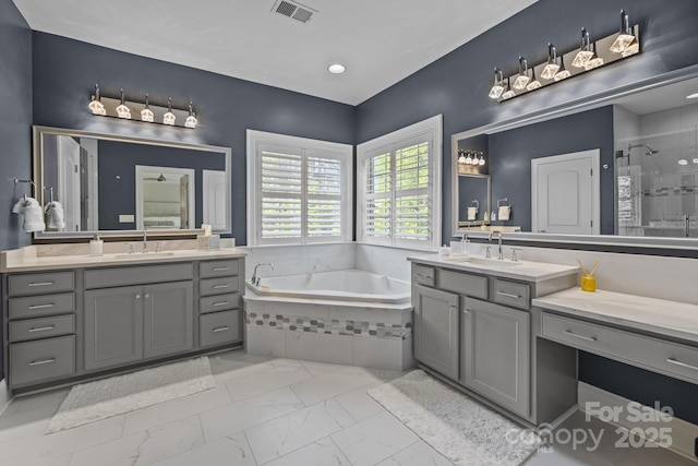 16522 Flintrock Falls Ln, Charlotte, NC 28278 - full bath featuring marble look tiles, a stall shower, two vanities, a garden tub, and recessed lighting