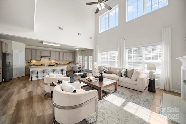 14801 Provence Ln, Charlotte, NC 28277 - living area featuring ceiling fan, a high ceiling, light wood-style flooring, and crown molding