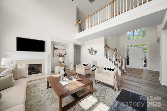 14801 Provence Ln, Charlotte, NC 28277 - living area featuring a towering ceiling, stairway, wood finished floors, a chandelier, and a high end fireplace