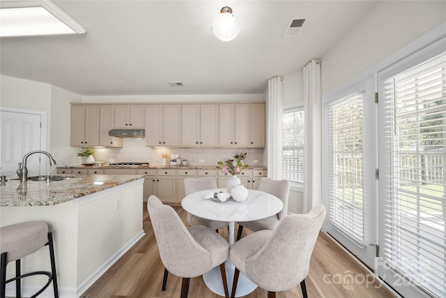 14801 Provence Ln, Charlotte, NC 28277 - kitchen with light wood-style floors, tasteful backsplash, and under cabinet range hood