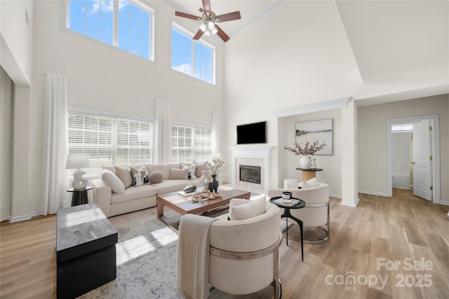 14801 Provence Ln, Charlotte, NC 28277 - living area featuring high vaulted ceiling, a ceiling fan, light wood-style floors, and a glass covered fireplace