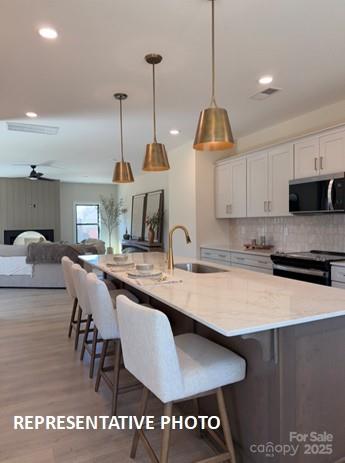 728 Falling Oak Aly Unit 21, Huntersville, NC 28078 - kitchen with black electric range, a ceiling fan, white cabinets, recessed lighting, and tasteful backsplash
