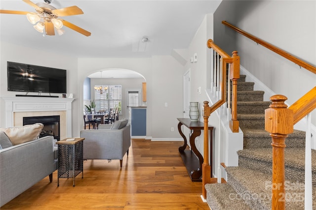 514 Bent Leaf Ct, Fort Mill, SC 29708 - living room featuring arched walkways, wood finished floors, a ceiling fan, stairway, and a fireplace