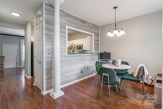 11521 Savannah Creek Dr, Charlotte, NC 28273 - dining space featuring an accent wall, ornate columns, wood finished floors, and a chandelier