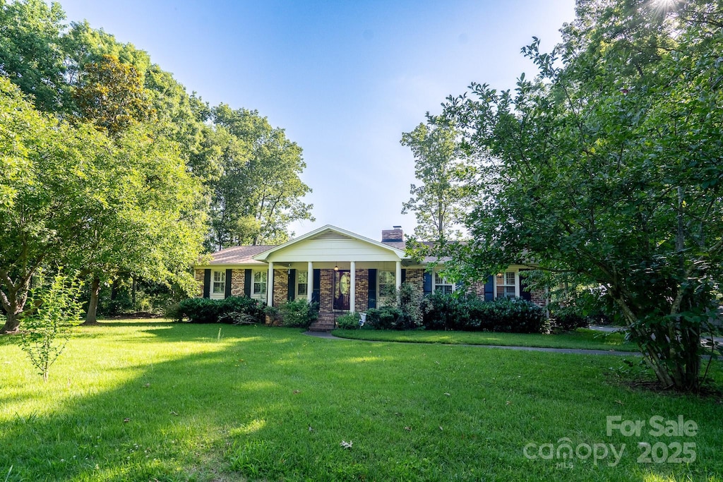 402 Scotland Dr, Kings Mountain, NC 28086 - view of front facade featuring a front lawn, a chimney, and brick siding