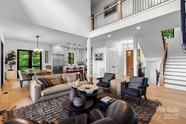 55 Steeplebush Ct Unit 629, Tuckasegee, NC 28783 - living area featuring light wood-style flooring, a chandelier, a high ceiling, and stairway