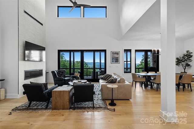55 Steeplebush Ct Unit 629, Tuckasegee, NC 28783 - living area featuring a high ceiling, light wood-type flooring, and a large fireplace