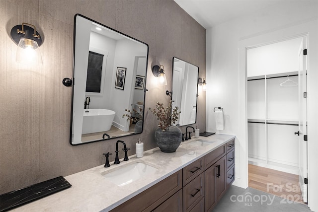 55 Steeplebush Ct Unit 629, Tuckasegee, NC 28783 - bathroom with double vanity, a soaking tub, a walk in closet, and wood finished floors
