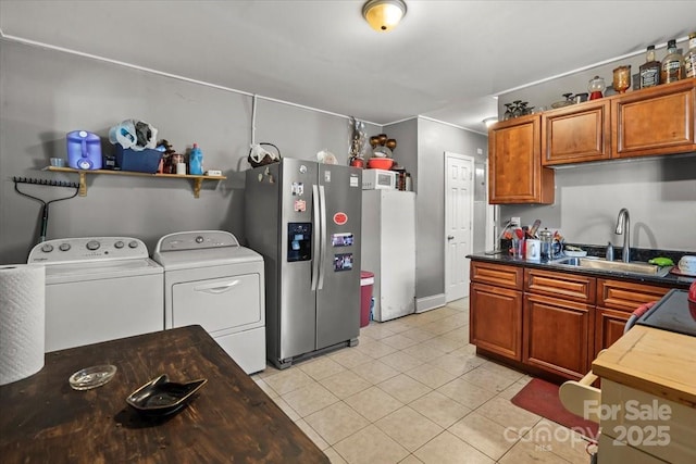 921 N Jackson St, Salisbury, NC 28144 - kitchen with stainless steel refrigerator with ice dispenser, separate washer and dryer, light tile patterned floors, and brown cabinetry