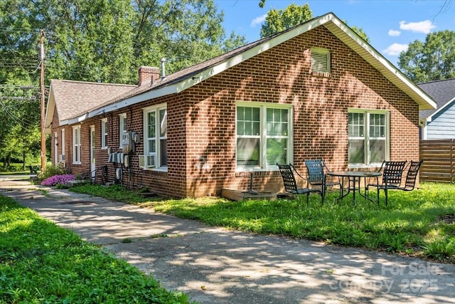 921 N Jackson St, Salisbury, NC 28144 - view of side of property featuring brick siding, a chimney, and cooling unit