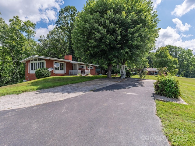 90 Hemlock Hill Hts, Canton, NC 28716 - view of front of home with driveway, a chimney, a front yard, brick siding, and covered porch