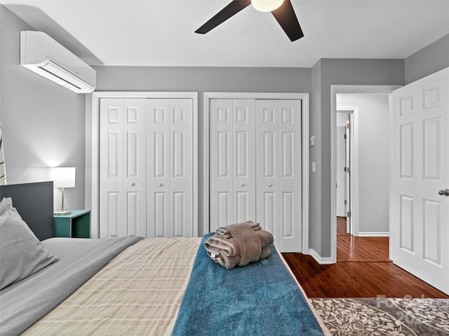 220 Deer Run Rd, Canton, NC 28716 - bedroom with a wall mounted air conditioner, two closets, wood finished floors, and a ceiling fan