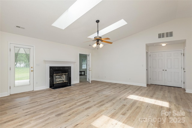 802 Woodlark Ct, Fletcher, NC 28732 - unfurnished living room featuring a skylight, vaulted ceiling, light wood-style flooring, a high end fireplace, and a ceiling fan