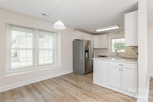 802 Woodlark Ct, Fletcher, NC 28732 - kitchen featuring stainless steel fridge with ice dispenser, light countertops, light wood-style flooring, white cabinetry, and hanging light fixtures