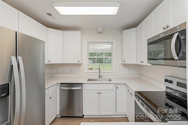 802 Woodlark Ct, Fletcher, NC 28732 - kitchen featuring stainless steel appliances, white cabinetry, light wood finished floors, and light countertops