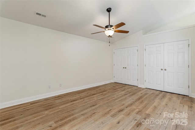 802 Woodlark Ct, Fletcher, NC 28732 - unfurnished bedroom with lofted ceiling, multiple closets, light wood-style flooring, and ceiling fan