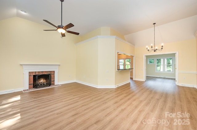 975 Pine Knoll Rd, Fort Mill, SC 29715 - unfurnished living room with a chandelier, high vaulted ceiling, a fireplace, light wood-style flooring, and a ceiling fan