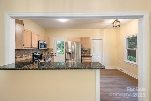 975 Pine Knoll Rd, Fort Mill, SC 29715 - kitchen with appliances with stainless steel finishes, a peninsula, backsplash, wood finished floors, and dark stone counters