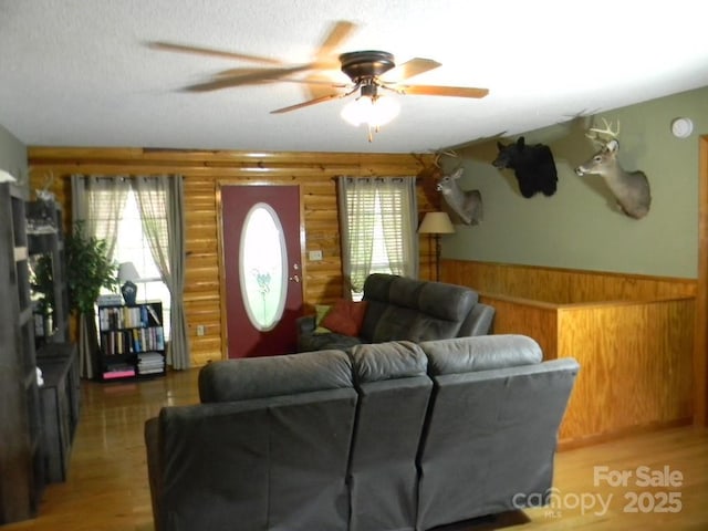 1425 Sorrells Cove Rd, Clyde, NC 28721 - living room featuring a wainscoted wall, ceiling fan, log walls, light wood finished floors, and wooden walls