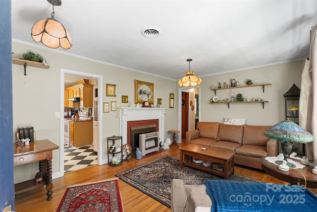 25 Wall Rd, Tryon, NC 28782 - living area with heating unit, crown molding, light wood-type flooring, and a brick fireplace
