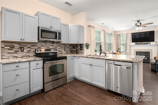 6422 Gatesville Ln, Charlotte, NC 28270 - kitchen featuring appliances with stainless steel finishes, a peninsula, open floor plan, dark wood-style flooring, and backsplash