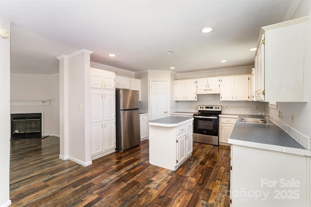508 Bridgestone Ln, Rock Hill, SC 29730 - kitchen with appliances with stainless steel finishes, under cabinet range hood, dark wood-style floors, white cabinets, and a kitchen island