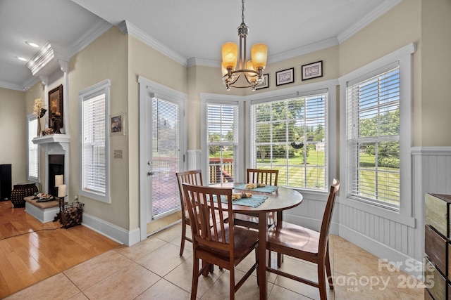 1006 Pin Oak Trl Unit 5, Hendersonville, NC 28739 - dining space featuring a chandelier, crown molding, healthy amount of natural light, a wainscoted wall, and light tile patterned floors