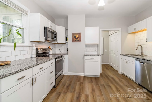 202 Gum St, Pageland, SC 29728 - kitchen featuring stainless steel appliances, backsplash, light stone countertops, and white cabinetry