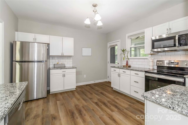202 Gum St, Pageland, SC 29728 - kitchen featuring stainless steel appliances, a chandelier, decorative backsplash, and white cabinetry
