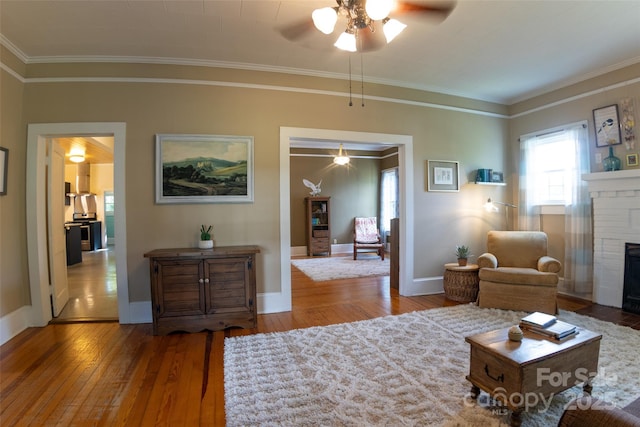 102 Cuthberson St, Morganton, NC 28655 - living area featuring ceiling fan, hardwood / wood-style flooring, a brick fireplace, and crown molding