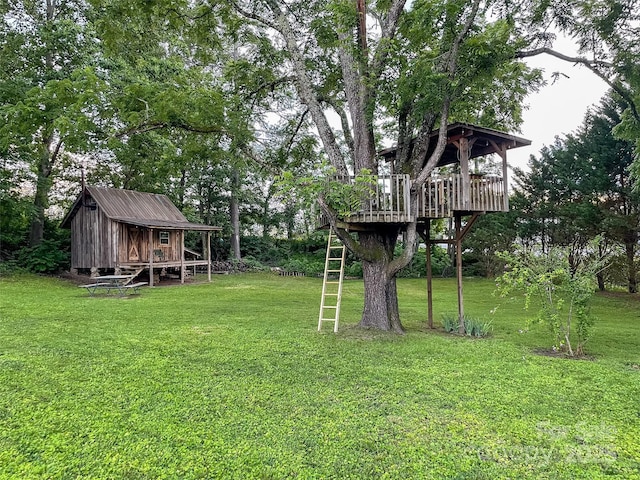 102 Cuthberson St, Morganton, NC 28655 - view of green lawn featuring a deck, a storage unit, and view of scattered trees