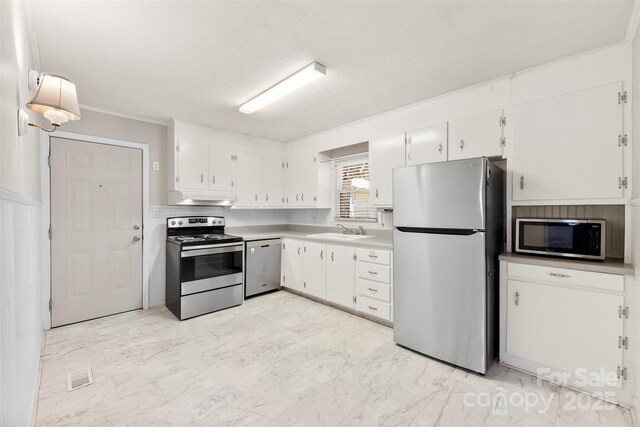 814 W Gold St, Kings Mountain, NC 28086 - kitchen with stainless steel appliances, light marble finish floors, under cabinet range hood, white cabinetry, and a textured ceiling