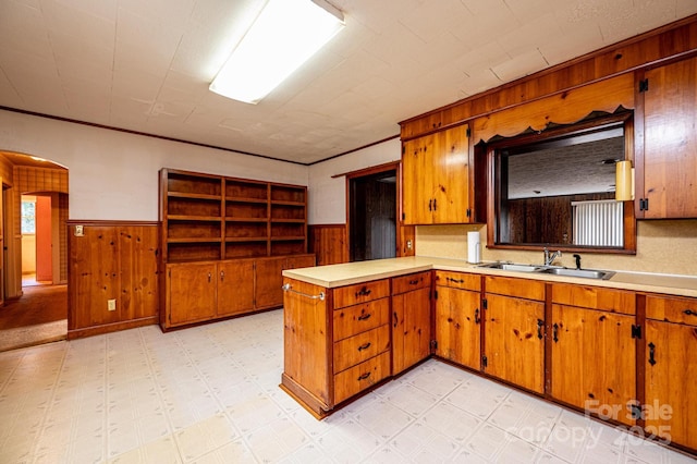 3954 E Burke Blvd, Connelly Springs, NC 28612 - kitchen featuring wainscoting, light countertops, wooden walls, brown cabinetry, and a peninsula