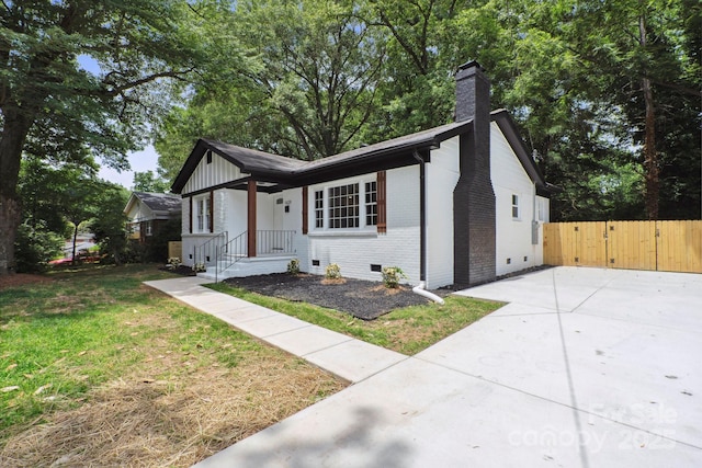 5420 Gwynne Ave, Charlotte, NC 28205 - view of front facade featuring brick siding, a chimney, crawl space, and a gate