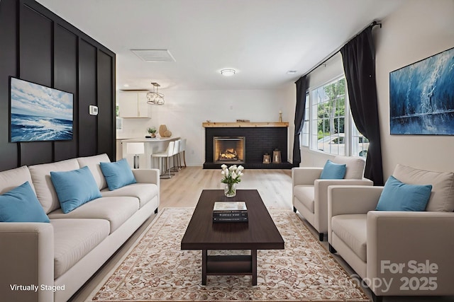 5420 Gwynne Ave, Charlotte, NC 28205 - living room with light wood-style flooring and a brick fireplace
