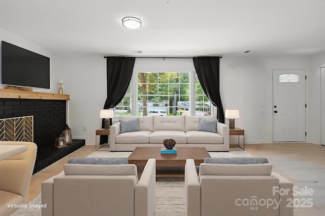 5420 Gwynne Ave, Charlotte, NC 28205 - living area featuring light wood-style floors and a brick fireplace
