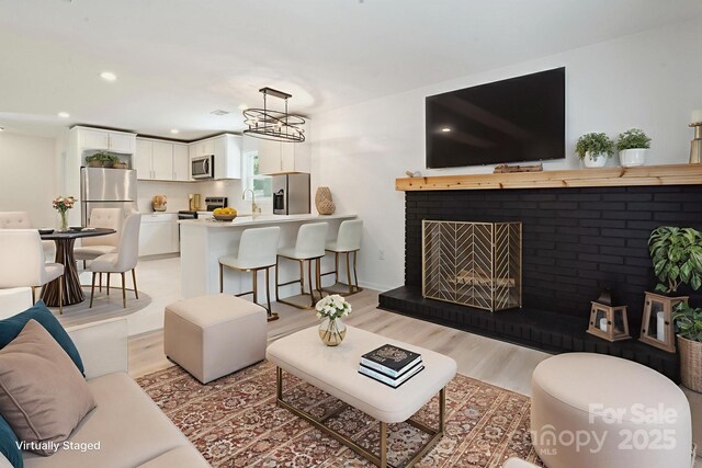 5420 Gwynne Ave, Charlotte, NC 28205 - living area featuring light wood-style flooring, a fireplace, and recessed lighting
