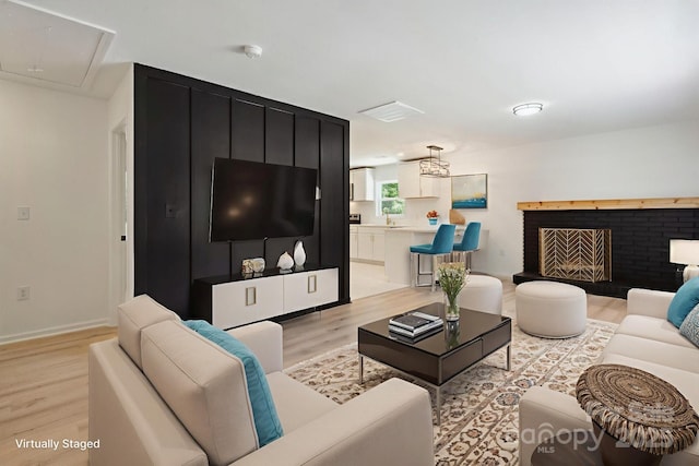5420 Gwynne Ave, Charlotte, NC 28205 - living area with light wood-type flooring, a brick fireplace, and attic access