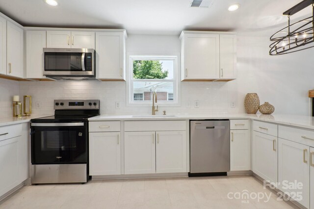 5420 Gwynne Ave, Charlotte, NC 28205 - kitchen with stainless steel appliances, white cabinets, light countertops, and recessed lighting