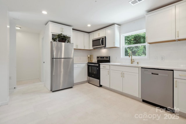 5420 Gwynne Ave, Charlotte, NC 28205 - kitchen with appliances with stainless steel finishes, tasteful backsplash, light countertops, white cabinets, and recessed lighting
