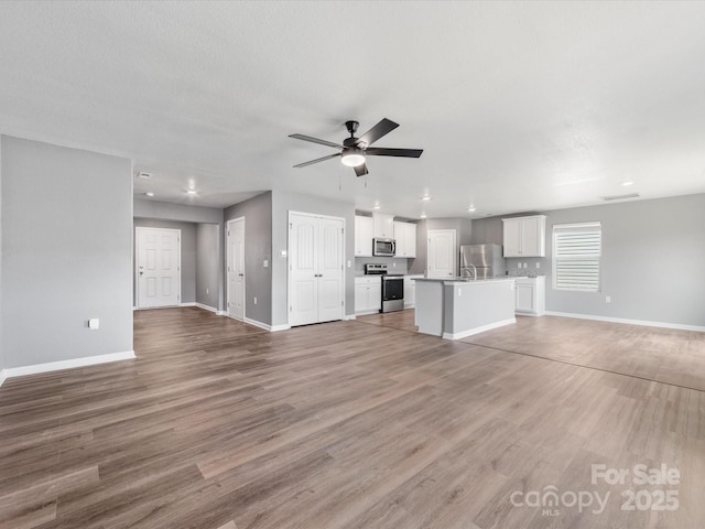 9136 Creedmore Hills Dr, Charlotte, NC 28214 - unfurnished living room with a ceiling fan, light wood-style floors, and recessed lighting