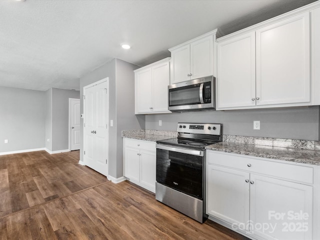 9136 Creedmore Hills Dr, Charlotte, NC 28214 - kitchen with stainless steel appliances, dark wood-style floors, light stone counters, recessed lighting, and white cabinetry