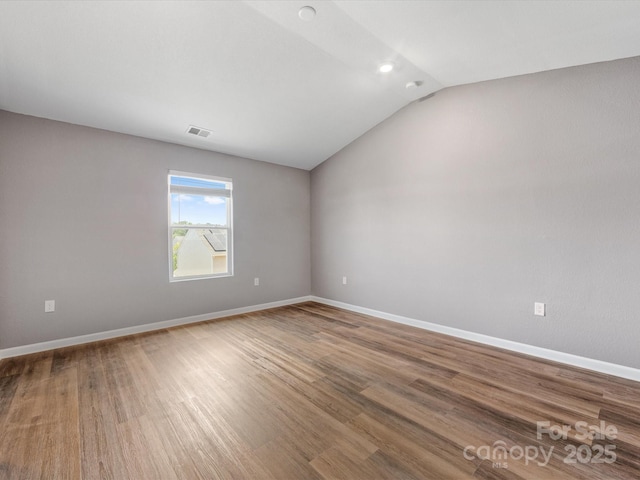9136 Creedmore Hills Dr, Charlotte, NC 28214 - spare room featuring vaulted ceiling and wood finished floors